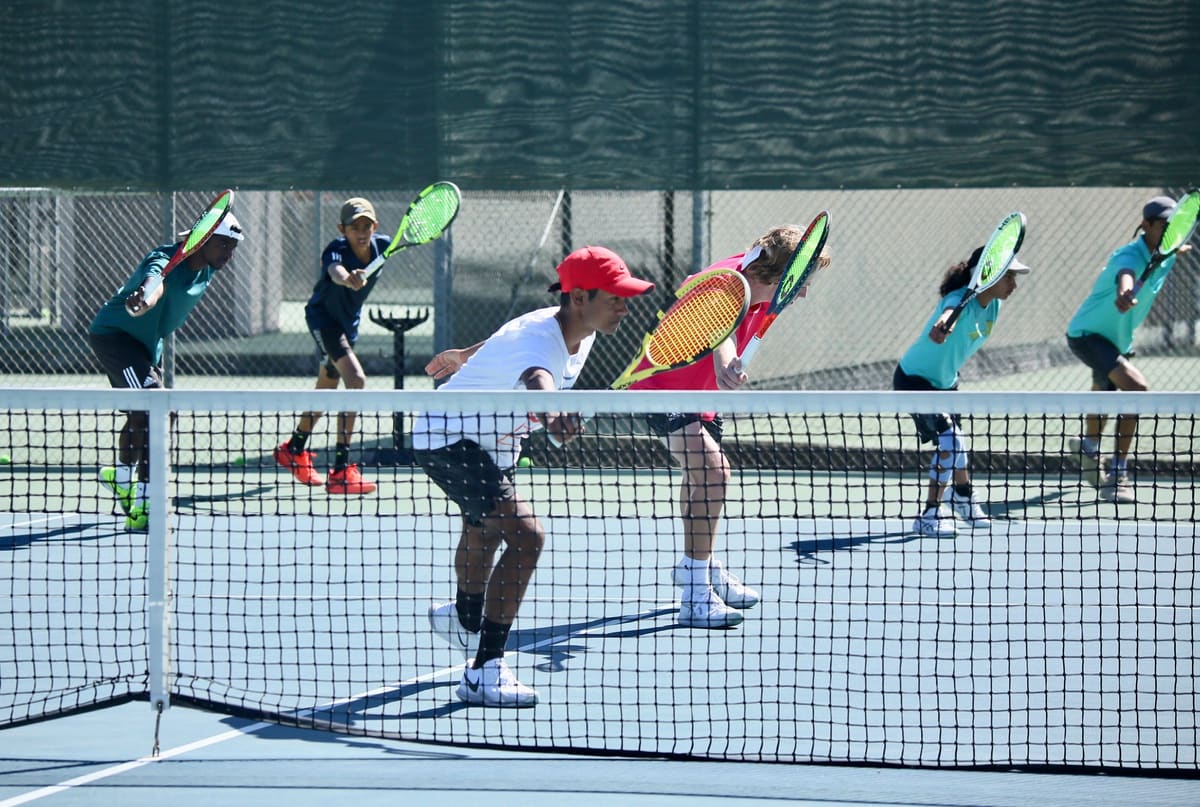 Young players at the net during a group drill