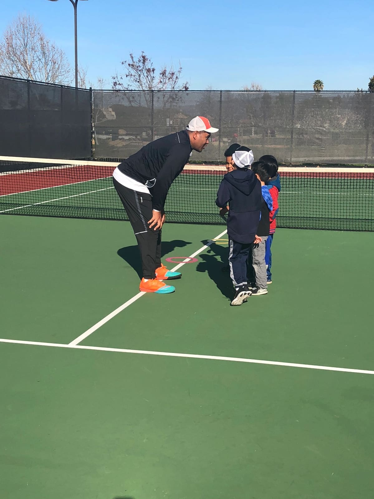 Coach crouching to talk with young players on a court