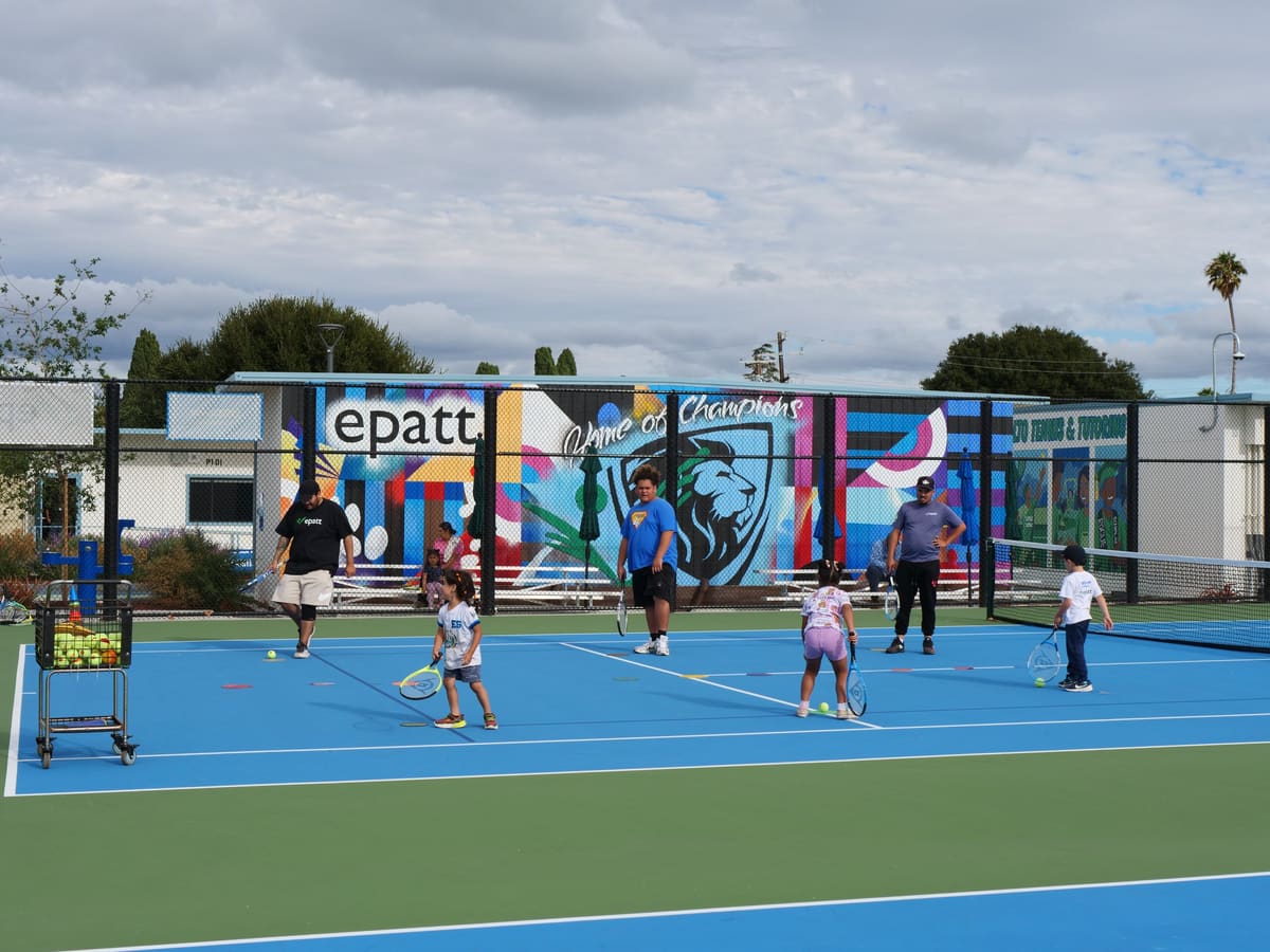 Kids and coaches playing tennis on the EPATT courts