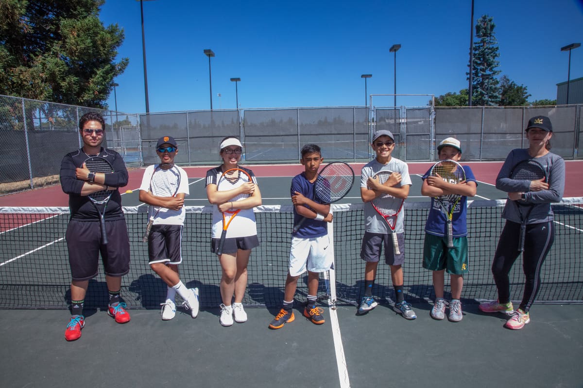 Coaches and young players lined up at the net