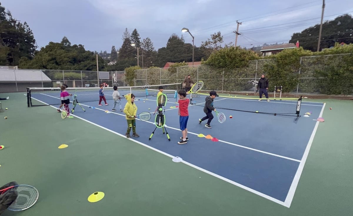 Young players practicing with rackets and cones on a Berkeley court