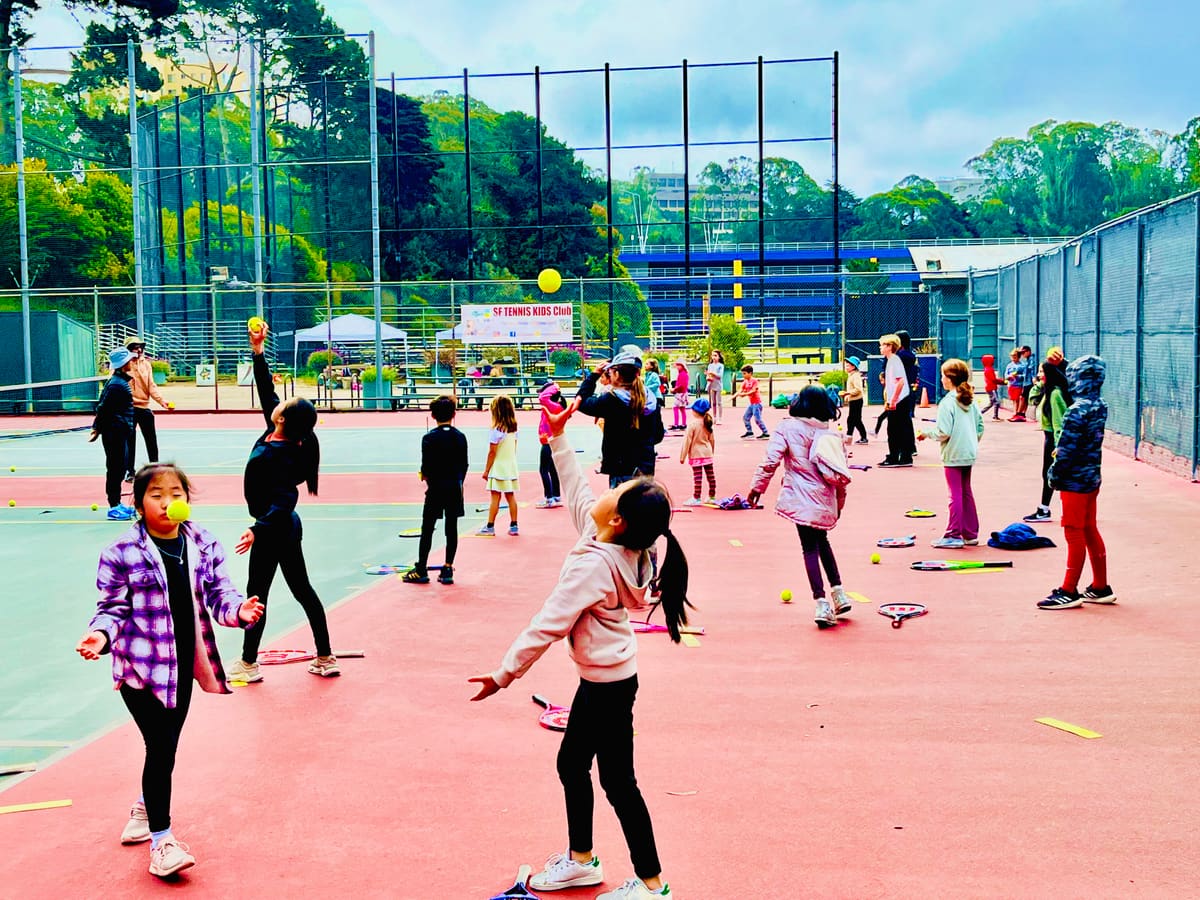 Kids with racquets and balls at a group lesson on the SF State courts
