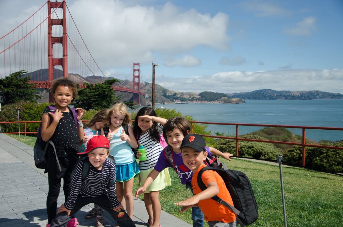 A group of campers posing in front of the Golden Gate Bridge